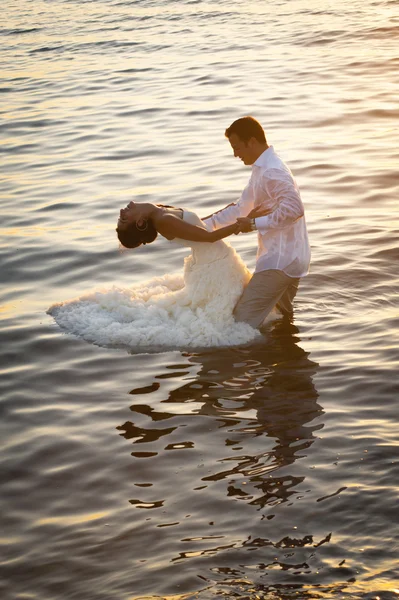 Couple nouvellement marié dansant dans l'eau — Photo