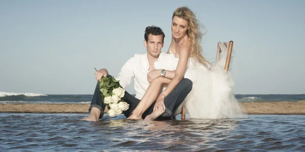 Couple assis sur la plage Image En Vente