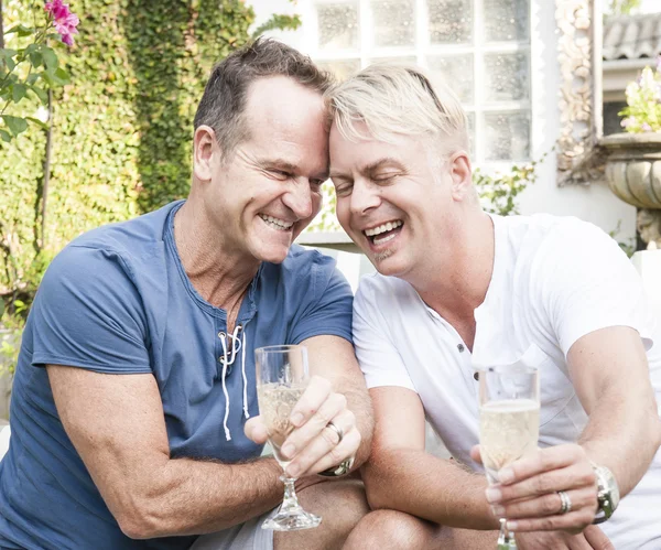 Handsome gay couple sharing an intimate moment over a glass of champagne — Stock Photo, Image