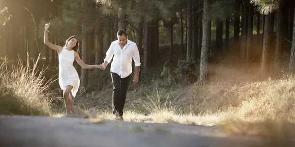 Young attractive Indian couple walking along dirt road — Stock Photo, Image