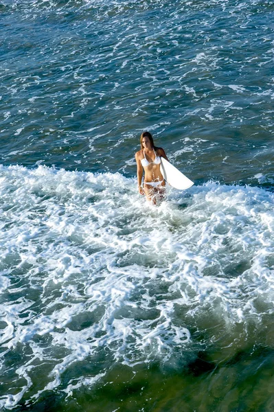 Menina surfista atraente jovem na praia com prancha de surf — Fotografia de Stock