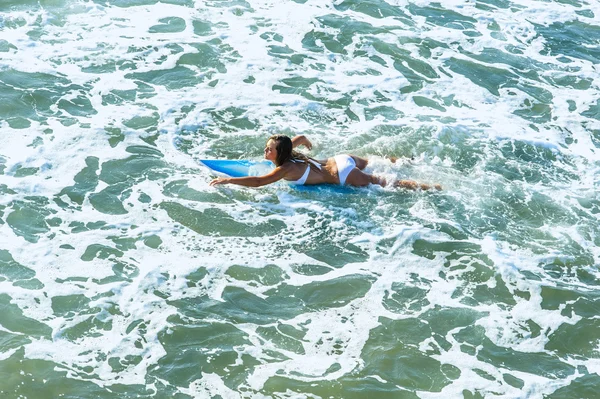 Young attractive surfer girl at the beach with surfboard — Stock Photo, Image