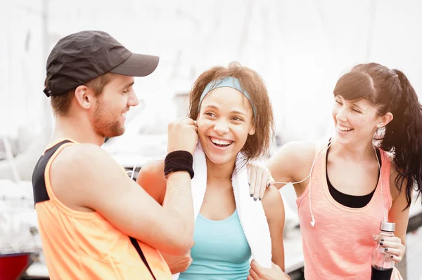 Grupo de jóvenes corredores atractivos charlando después de una sesión de ejercicio —  Fotos de Stock