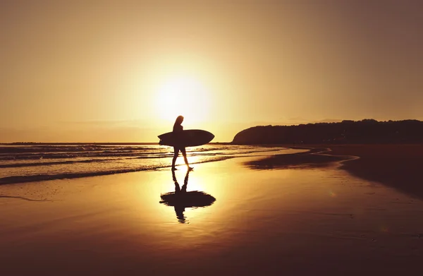 Young attractive surfer girl on beach with surf board — Stock Photo, Image