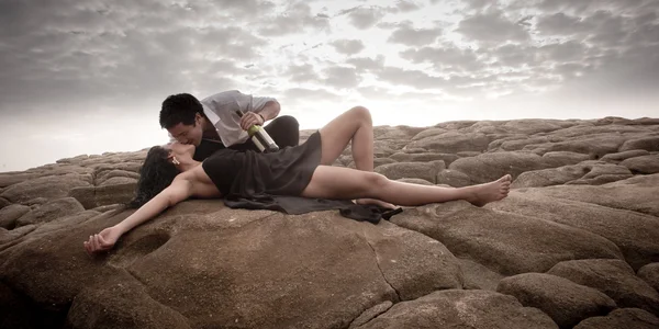 Beautiful couple flirting and having fun together on beach rocks — Stock Photo, Image