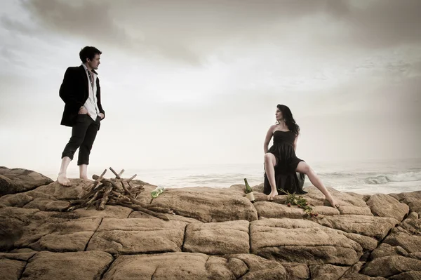 Beautiful couple flirting and having fun together on beach rocks — Stock Photo, Image