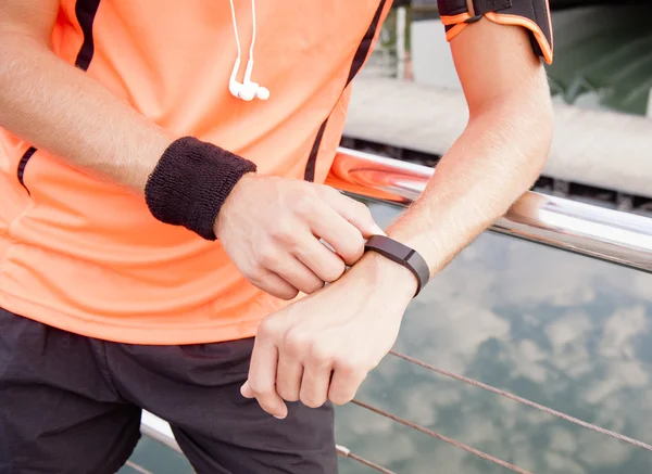 Young attractive guy leaning against railing with exercise gear — Stock Photo, Image