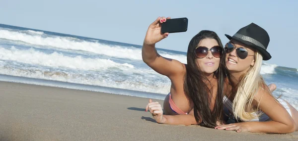 Dos chicas lesbianas atractivas jóvenes tomando una foto selfie en la playa — Foto de Stock