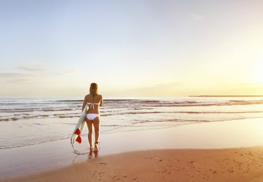 Genç çekici sörfçü kız plajda surfboard ile