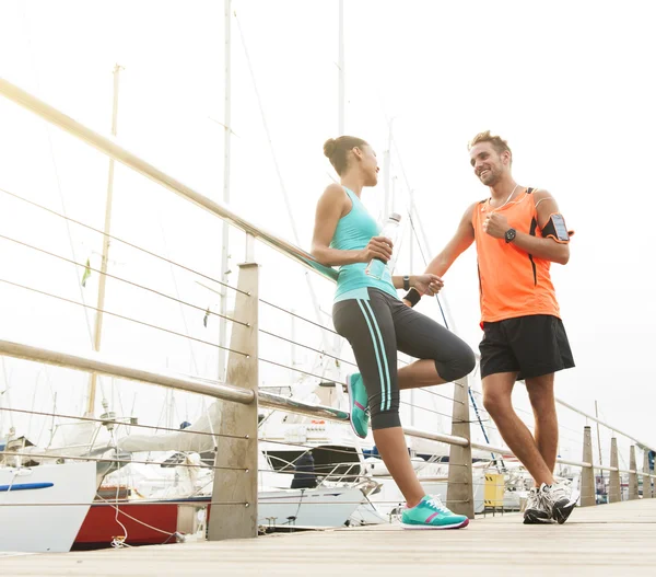 Dos corredores de carreras mixtas felices charlando después de ejercicios matutinos — Foto de Stock