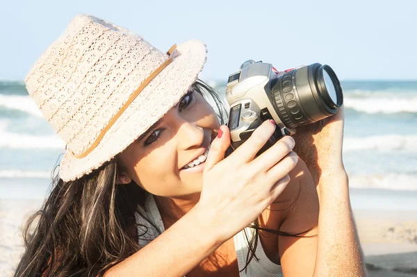 年轻有吸引力的女孩在海滩的相机拍照 — 图库照片