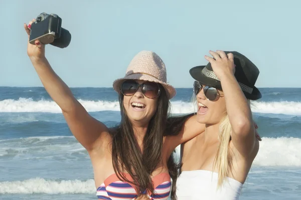 Twee jonge aantrekkelijke lesbische meisjes nemen selfie foto met camera op strand — Stockfoto