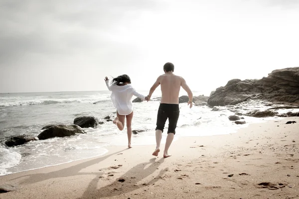 Unga vackra attraktiva par njuter av tiden tillsammans flirta på stranden — Stockfoto