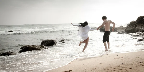 Unga vackra attraktiva par njuter av tiden tillsammans flirta på stranden — Stockfoto