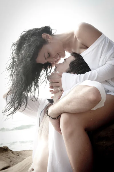 Joven enamorada pareja coqueteando en la playa — Foto de Stock