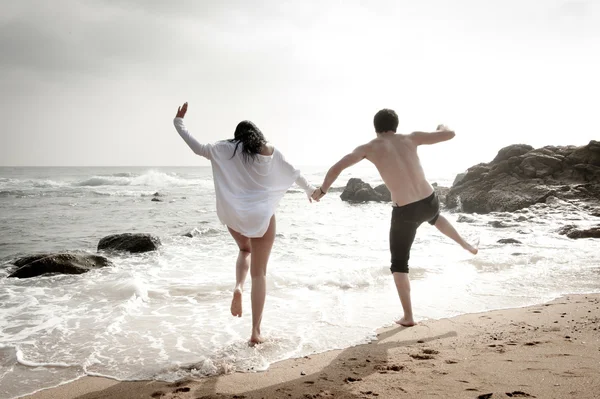 Молодая влюбленная пара флиртует на пляже — стоковое фото