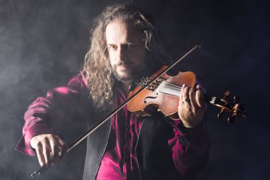 yakışıklı adam mavi duman ile Klasik keman çalıyor
