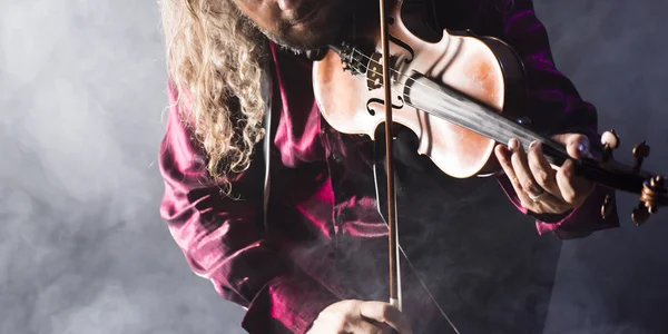 Hombre guapo tocando violín clásico a través de humo azul —  Fotos de Stock