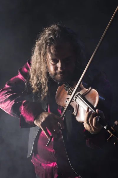 Hombre guapo tocando violín clásico a través de humo azul — Foto de Stock