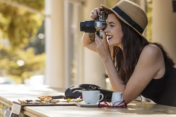 Young beautiful traveler happily taking photos with camera at ca — Stock Photo, Image