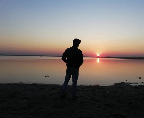 Alleen Mannen Zien Zonsondergang Oever Van Rivier Reflectie — Stockfoto