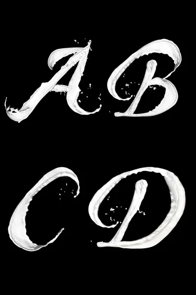 Buchstaben aus Milchspritzern a b c d Stockbild