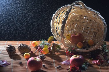 Sonbahar durgun yaşamı, elma, koni ve böğürtlen dolu sepet, yağmur