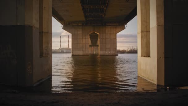 Vista inferior em um rio sob uma grande ponte industrial — Vídeo de Stock