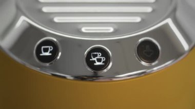 Kadın parmağı, merkezi çift espresso düğmesine basıyor.