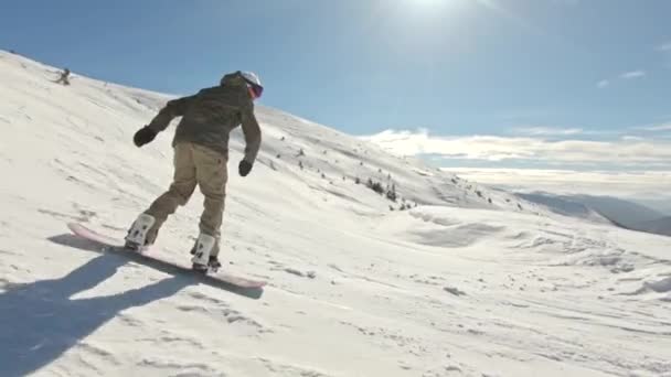 Snowboarder robi 360 na zapleczu w dzień błękitnego ptaka — Wideo stockowe