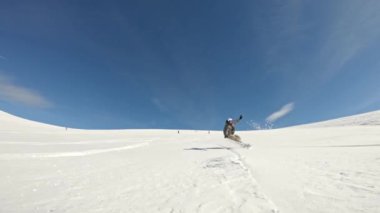 Bir snowboardcunun pistte aşağı inişi.