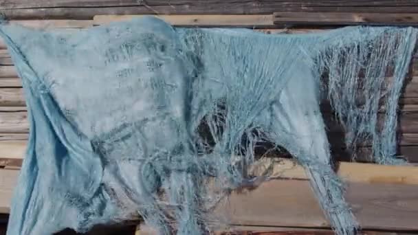Oude vuile blauwe doek zwaaiend op een wind op een houten muur — Stockvideo