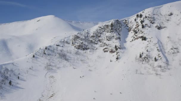 화창 한 겨울날 눈으로 덮인 바위투성이의 산들의 경치 — 비디오