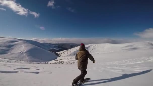 Snowboarder rider backcountry pulver i bergen på en blåsångare dag — Stockvideo