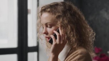 Telefondan konuşan 30 'lu yaşlarda biri. Akıllı telefonuna cevap veren bir iş kadınının yakınına.