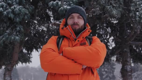 Confiado hombre de 30 años caucásico mirando con los brazos cruzados en un día nevado de invierno afuera — Vídeo de stock