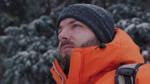 Молодой парень ищет где-то в морозный и снежный зимний день — стоковое видео