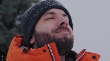 Yetişkin Kafkasyalı adam derin bir kış havası soluyor.