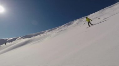 Dağlarda güneşli bir kış gününde, bir snowboard 'da tam gaz gidiş.
