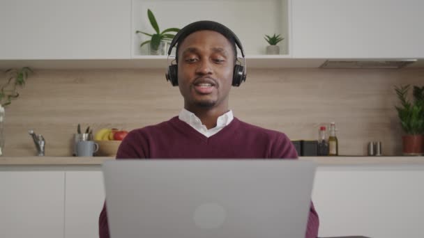 幸せなアフリカ系アメリカ人コールセンターの従業員サポートセールスマネージャーは、ヘッドセットとラップトップコンピュータを使用してクライアントと話しています — ストック動画