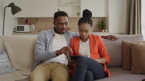 Young african american family is surfing the web on the tablet computer while shopping online — Stock Video