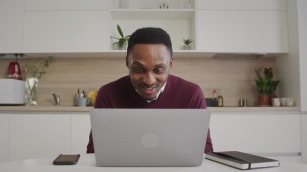 Felice uomo afro-americano sorridente che saluta il figlio neonato in una videochiamata su un portatile all'interno di casa — Video Stock