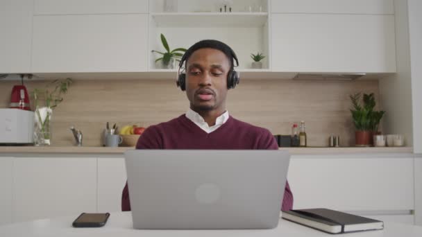非洲裔美国人呼叫中心的工作人员在他的公寓里用电信和笔记本电脑从家里打电话 — 图库视频影像