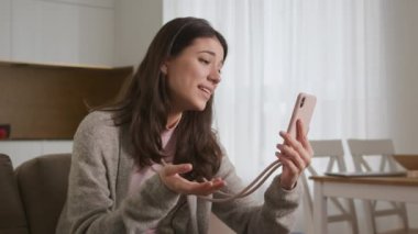 Beyaz bir kadın pembe akıllı telefon kullanarak arkadaşlarına ya da ailesine selam veriyor.