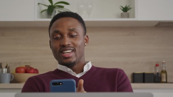 आनंदी हसत आफ्रिकन अमेरिकन माणूस घरी अंतर्गत लॅपटॉप वर व्हिडिओ कॉल त्याच्या मित्रांना सलाम — स्टॉक व्हिडिओ