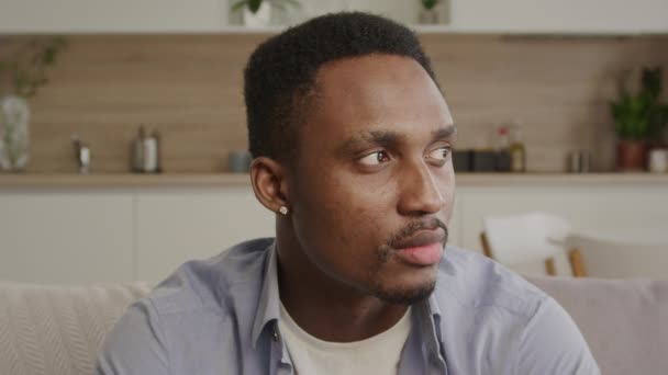 Close up retrato de um homem americano africano adulto olhando para os lados e, em seguida, transformando-se em câmera em olhar direto na lente — Vídeo de Stock