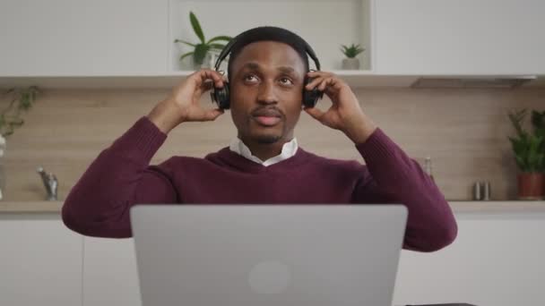 Un homme afro-américain de 20 ans met ses écouteurs hors tension tout en listant à quelqu'un devant lui — Video