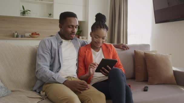 Young african american family is surfing the web on the tablet computer while shopping online — Stock Video