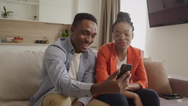 Africano casal americano ter uma conversa através de uma chamada de vídeo no telefone inteligente com seus amigos — Vídeo de Stock