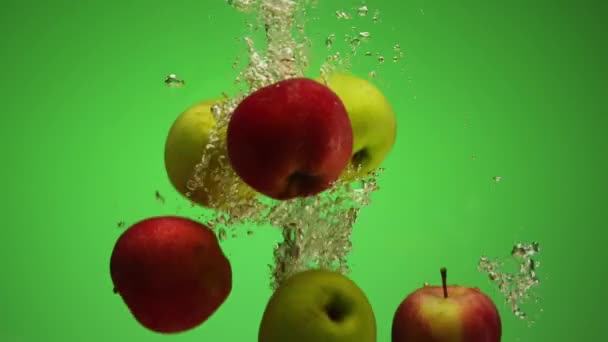 Gruppe gemischter roter und grüner Äpfel, die in Zeitlupe ins Wasser fallen — Stockvideo